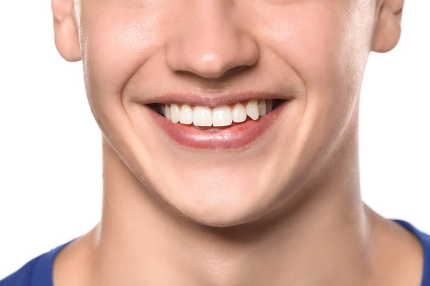 young man with healthy teeth smiling on white background, closeup